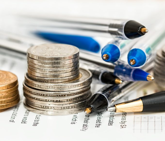 Person reviewing household bills and financial expenses while experiencing money-related stress