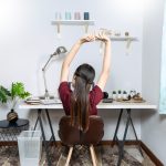 Office worker stretching beside a desk during the workday.